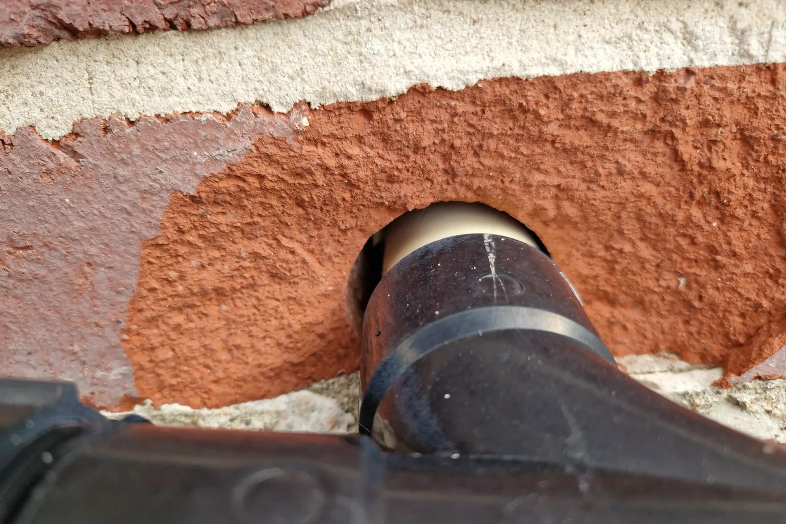 A gap around a kitchen waste pipe where it enters an outside wall